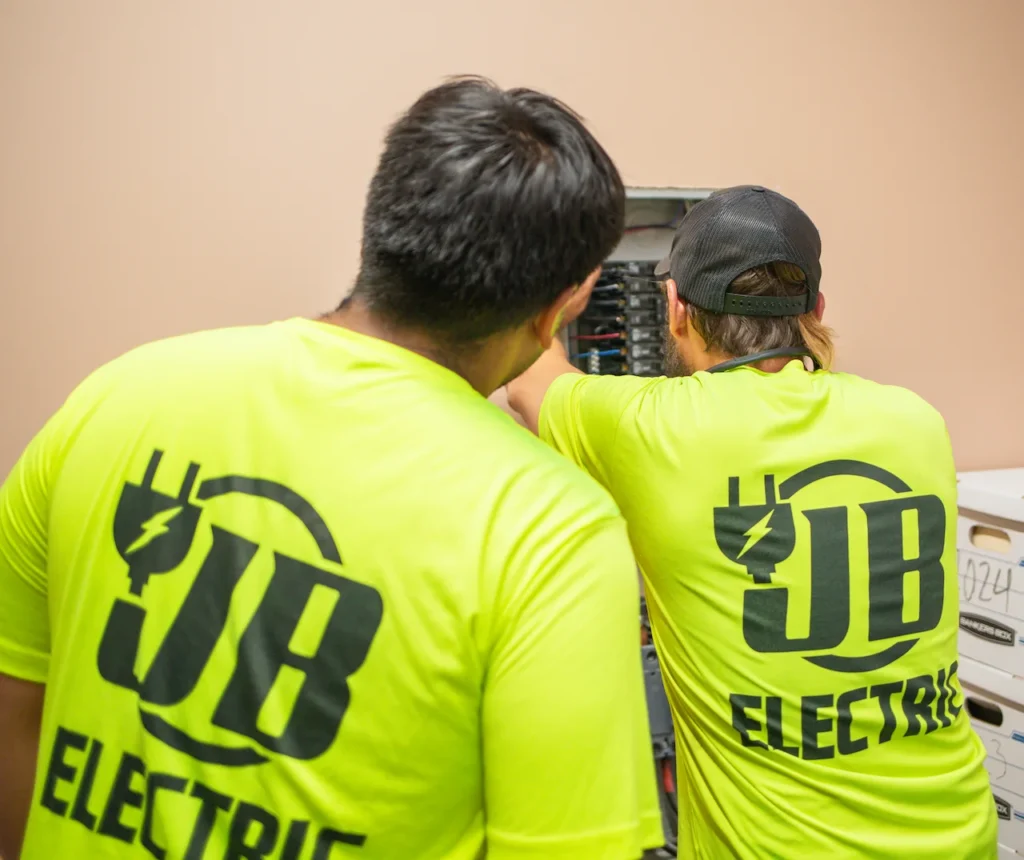 Electricians working on circuit breaker panel.