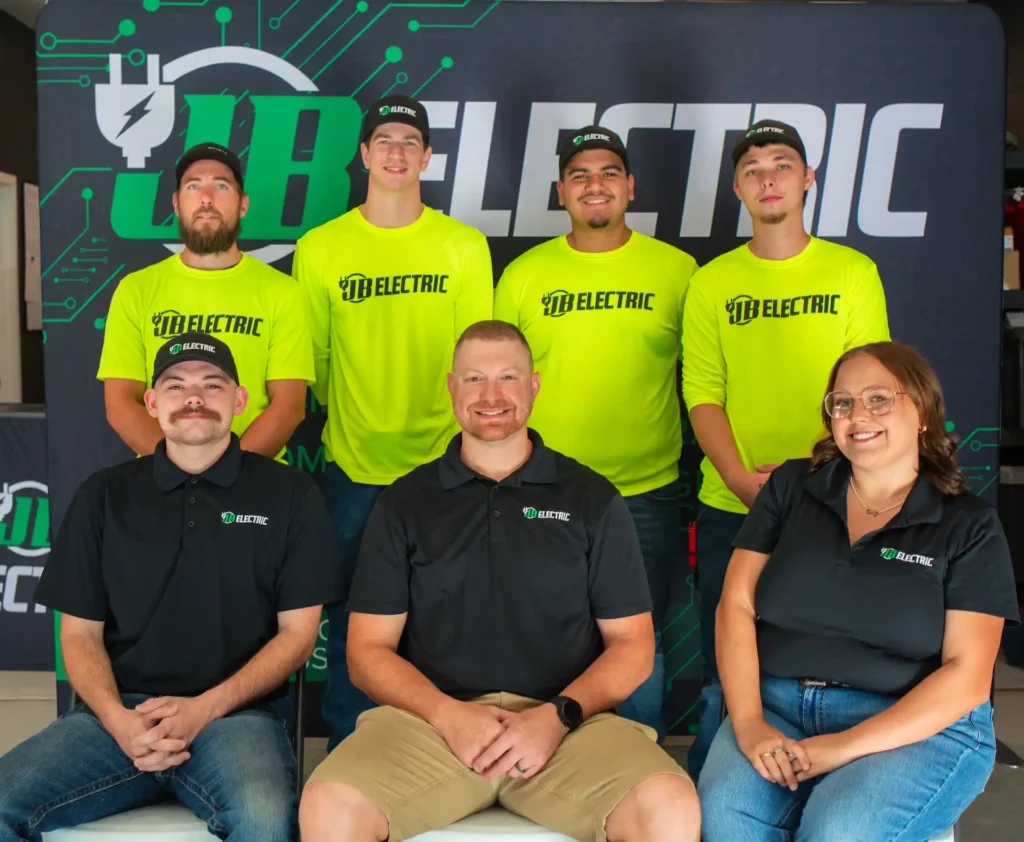 JB Electric team group photo in branded shirts.
