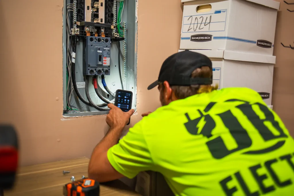 Electrician inspecting electrical panel with smartphone.