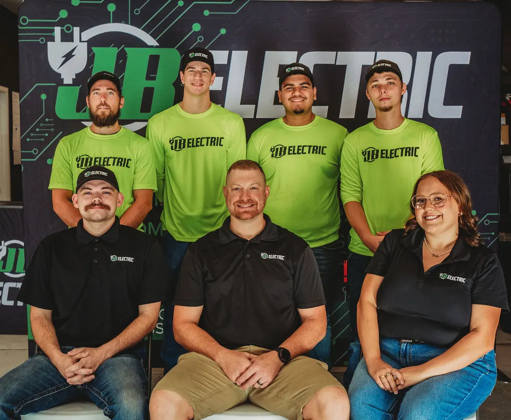 JB Electric team group photo in branded shirts.