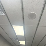 Office ceiling with lighting panels and speaker.