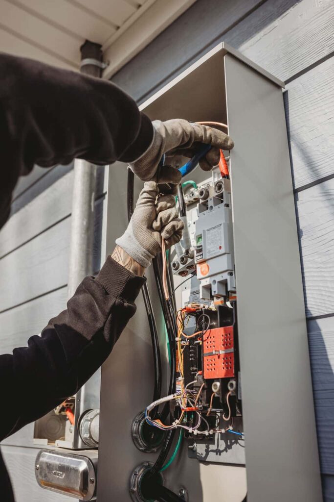 Electrician fixing outdoor electrical panel box.