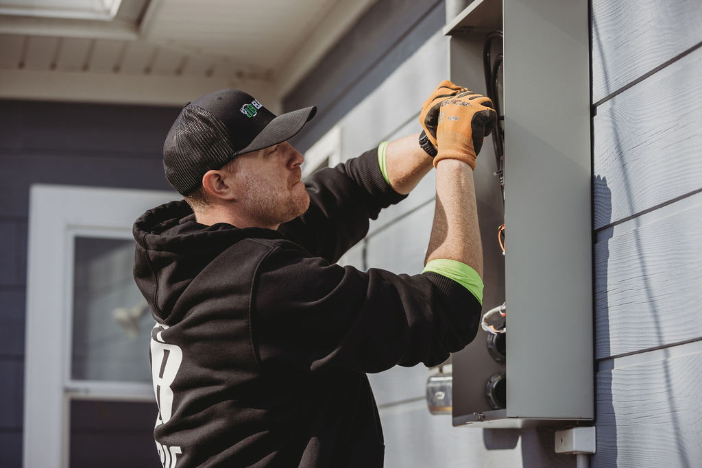 Electrician working on outdoor electrical panel.