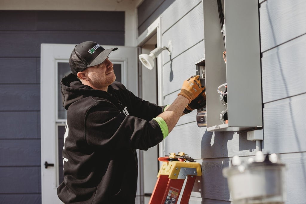 Electrician fixing outdoor electrical panel