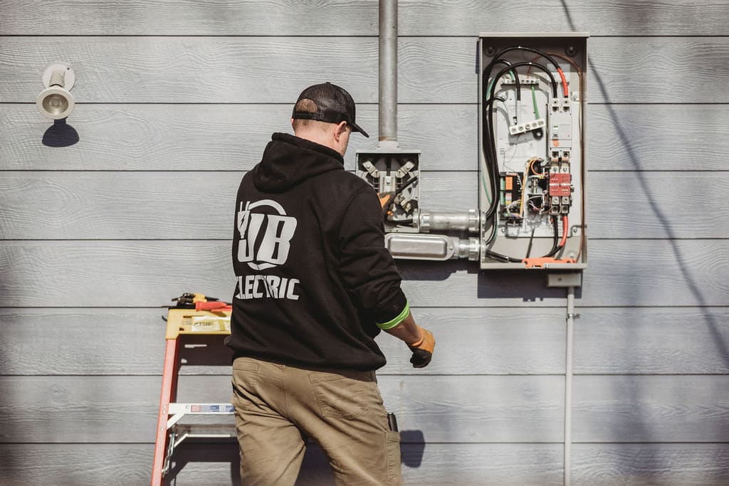 Electrician working on outdoor electrical panel