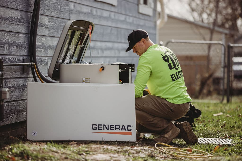 Electrician installing outdoor Generac generator system.