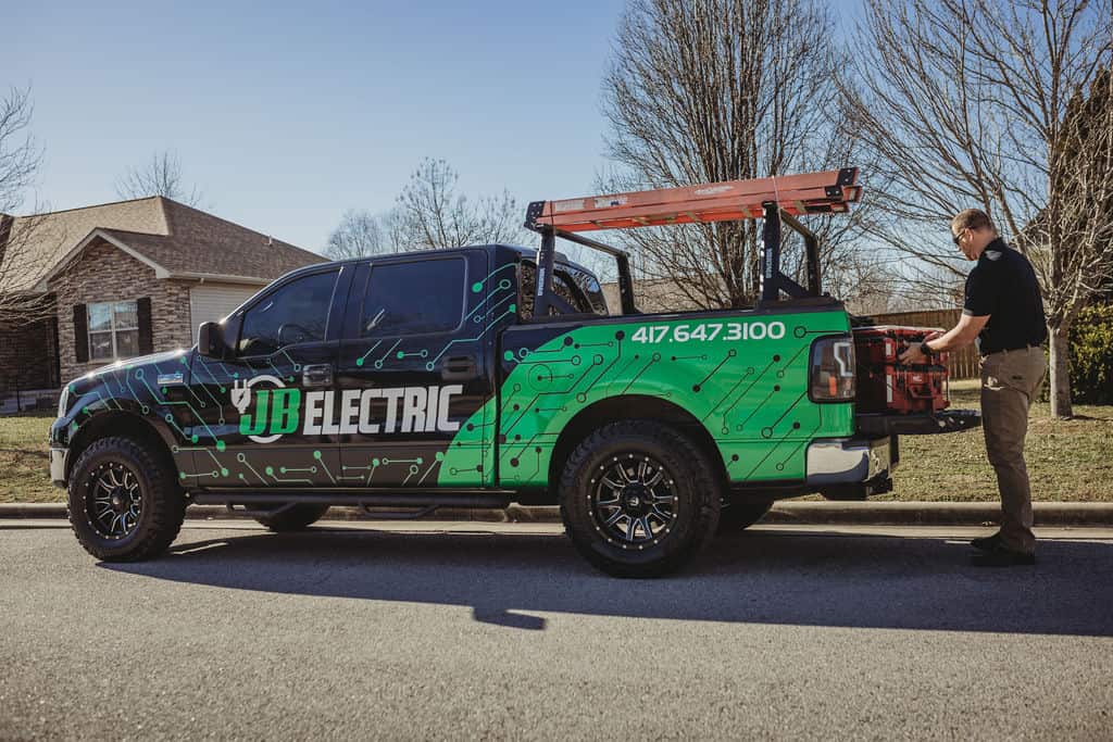 Electrician loading tools into company truck