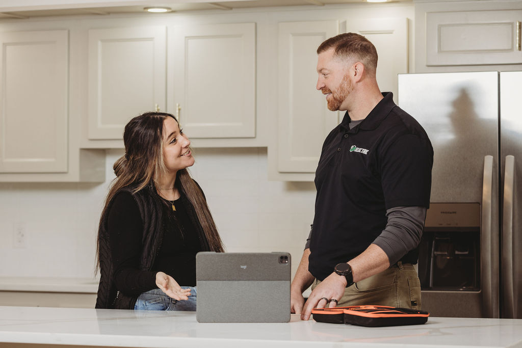 Two people discussing over a kitchen countertop.