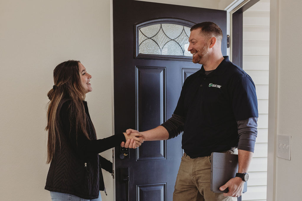 Two people shaking hands at doorway.
