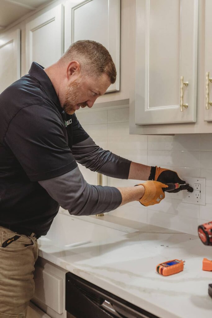 Electrician fixing kitchen electrical outlet