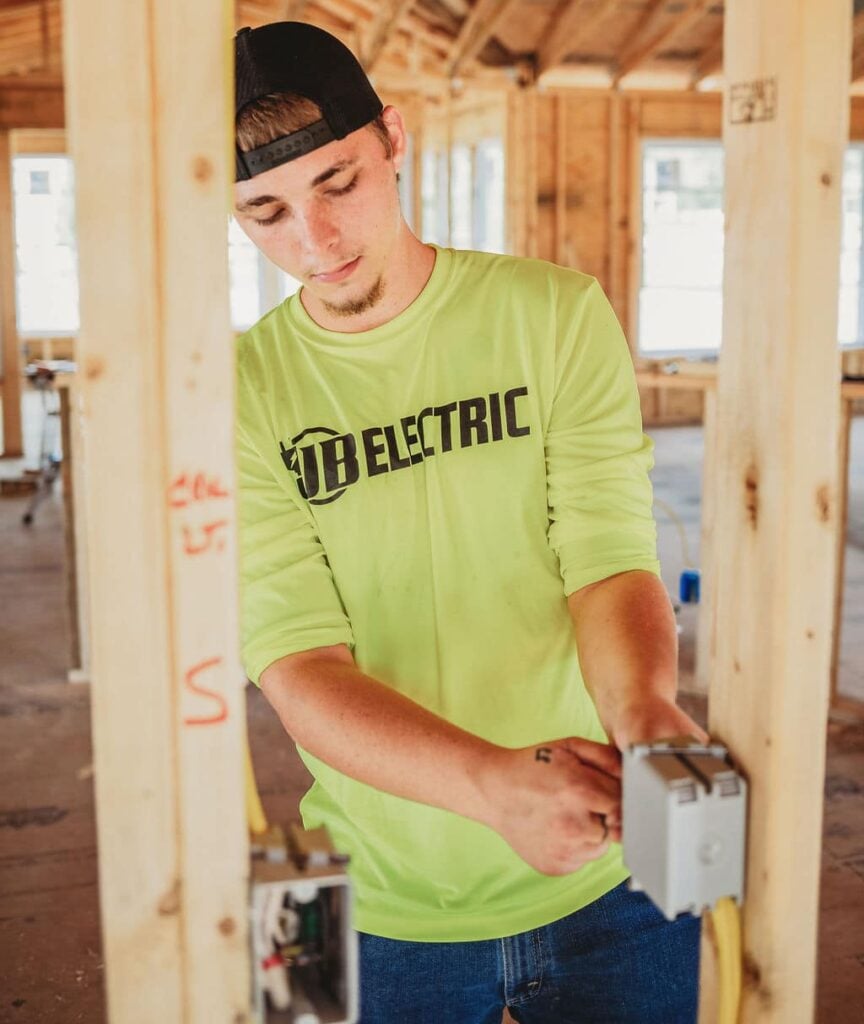 Electrician wiring in wooden framed house
