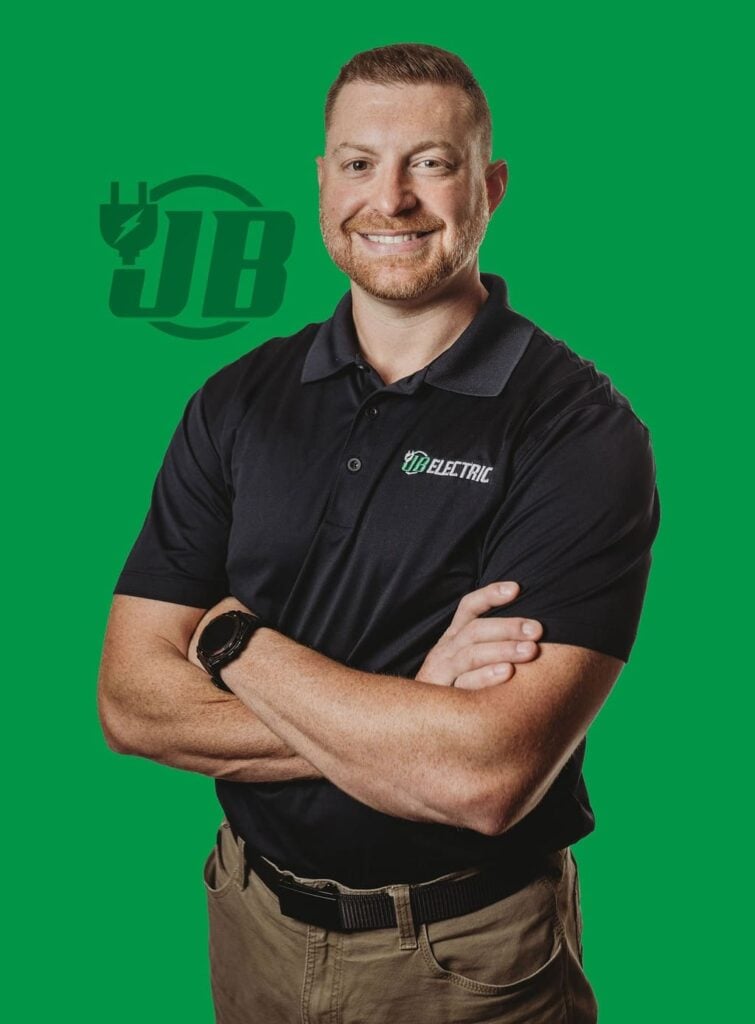 Man in JB Electric shirt on green background.