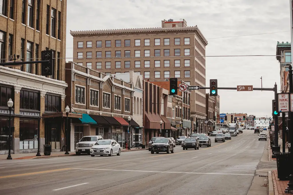 Busy urban street with cars and historic buildings.